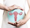 Torso of a woman holding an image of her uterus in front of her body